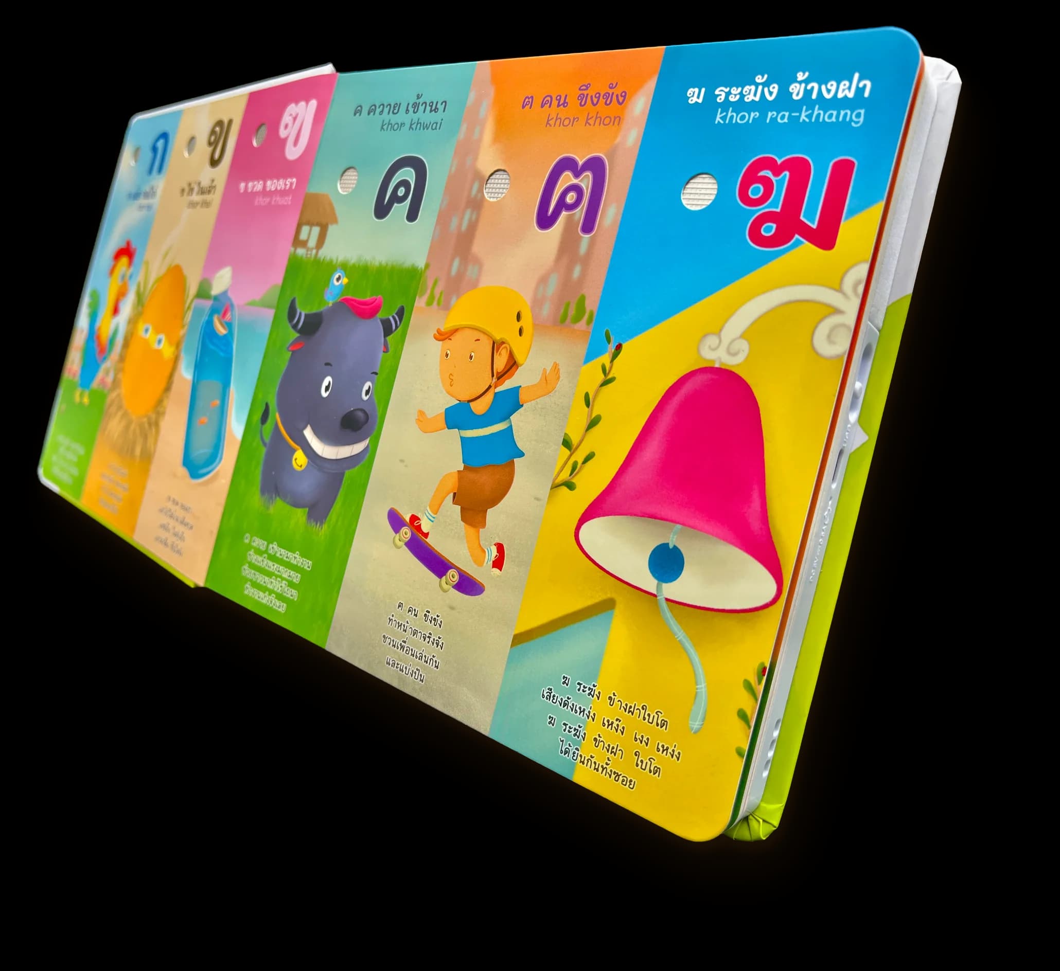 หนังสือ กขค ปาร์ตี้ เปิดอยู่ หน้า ค ควาย ฅ คน ฆ ระฆัง มีรูกลมข้างตัวอักษร